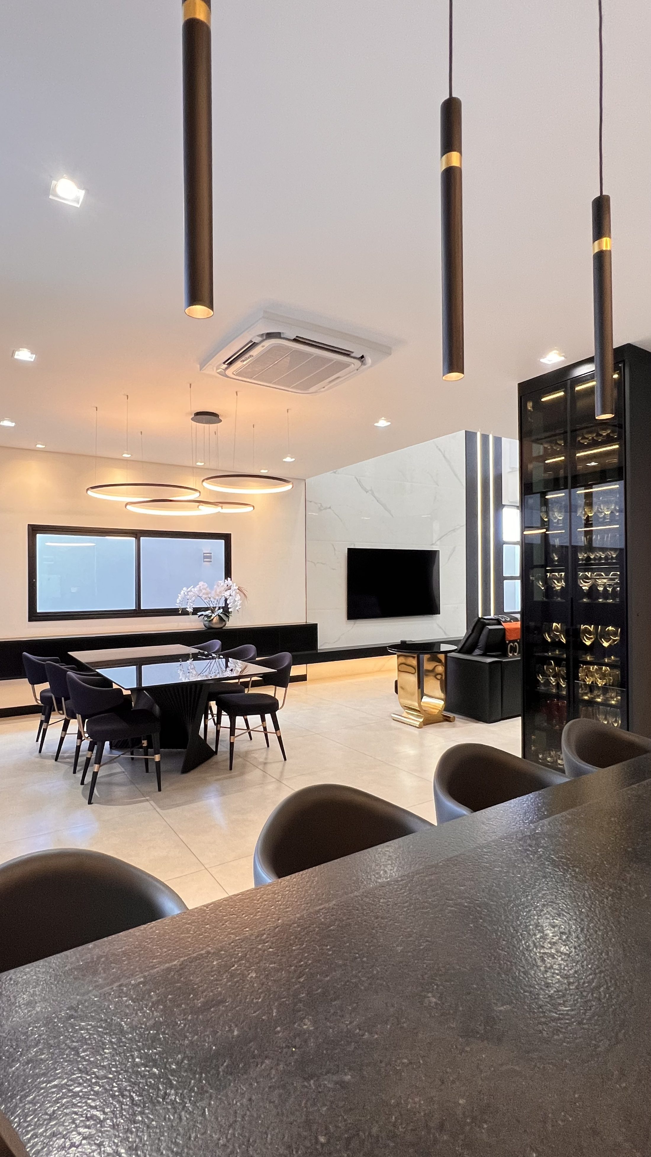 Sala de jantar e estar de alto padrão planejada pela Villa, com painel em mármore e adega